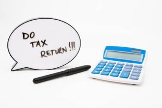 Do your tax return concept with text in speech bubble and calculator on white background